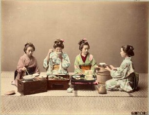 Vier Japanerinnen beim Essen von Reis