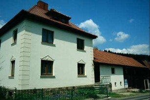 Wohnhaus mit Schmuckelementen über den Fenstern; Vorgarten