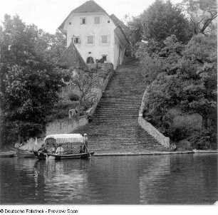 Blick vom Bleder See zum Ufer gegen Boot, Treppenanlage mit Anlegestelle und Wohnhaus