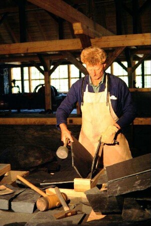 Schiefermuseum: Leiter des Museums Herr Liebeskind beim Spalten einer Schieferplatte