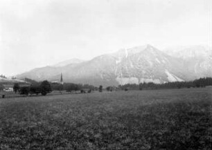 Deutschland? Alpen. Blick über eine Wiese gegen Berge