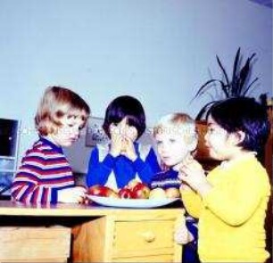 Kinder der Kinderkombination Karl-Marx-Stadt essen Äpfel