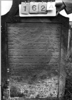 Grabstein 162 (Index: 100107436) Material: gelber Sandstein Zustand: stark verwittert und versalzen, weitgehender Textverlust Maße HxBxT: 132x71x15 cm Beschreibung: Stele in Sonderform, Schriftfeld eingetieft: Grabstein 162A