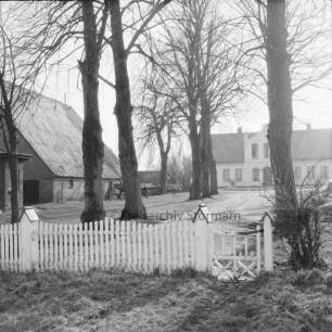 Anwesen "Klosterhof": links Wirtschaftsgebäude: vorn Holzzaun: dahinter Bäume: im Hintergrund Gutshaus