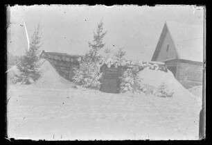Haus (mit Blockhütte davor) im Schnee