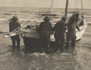 Pommersche Küste. Bei Ahlbeck. Vier Fischer ziehen ein Fischerboot an Land