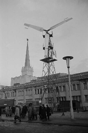 Messebesucher auf dem Ausstellungsgelände mit einem in der UdSSR hergestellten Windrad, im Hintergrund der sowjetische Pavillon