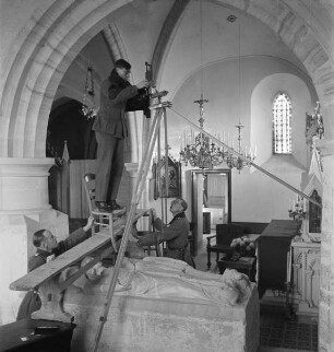 Hans-Adalbert von Stockhausen (links), Carl Albiker (Mitte) und Franz Prinz zu Sayn-Wittgenstein (rechts) beim Fotografieren eines Doppelgrabs in einer kleinen Kirche (Aufnahme im Rahmen der Fotokampagne im besetzten Frankreich)