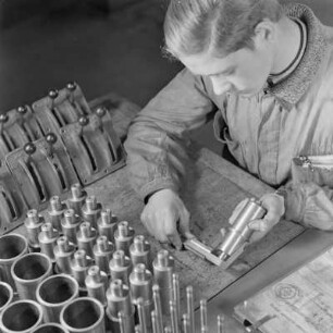 Lehrling bei Borgward misst ein Bauelement