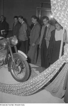 Besucher der Technischen Messe 1953 an einem Stand mit einem Motorrad