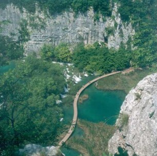Kroatien. Nationalpark Plitvicer Seen. Blick auf einen Holzsteg mit Touristen