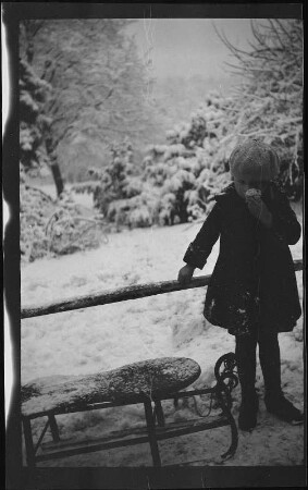 Mädchen mit Schlitten im winterlichen Park