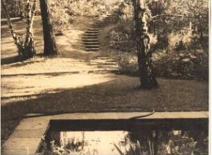 Garten Dr. Bahr: Blick vom Wasserbecken zur Treppe im Garten, die zur Sitzecke auf Anhöhe führt