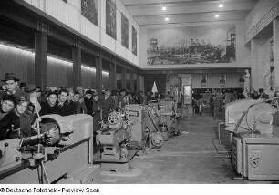 Besucher an einem Messestand mit Maschinen im Ausstellungspavillon von China