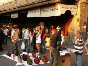 nach Ladenschluß der Geschäfte auf der Ponte Vecchio verkaufen Schwarzafrikaner gefälschte Markenartikel an Passanten