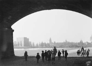 Dresden-Neustadt, Kindergruppe mit Betreuerinnen. Blick unter einem Brückenbogen der Brücke der Einheit (Albertbrücke) auf die Dr.-Rudolf-Friedrichs-Brücke (Carolabrücke) im Wiederaufbau