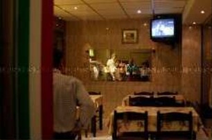 Männer schauen in einem Imbiss das Endspiel der Fußball-WM (Prämiertes Foto Sonderthema: Fußball-Fieber)