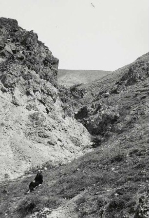 Gebirgslandschaft. Etha Richter auf einem Fels sitzend