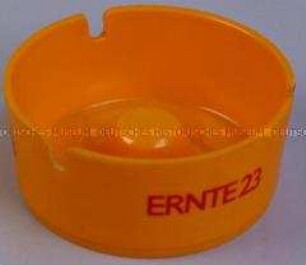 Aschenbecher (orange) mit Werbeaufdruck für "Ernte 23"-Zigaretten