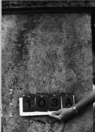 Grabstein 103 (Index: 99618519) Maße HxBxT: 190x72x48 cm Beschreibung: aufgesetzte Urne Symbolik: Mohnkapseln und -blätter, Schmetterling: Grabstein 103A