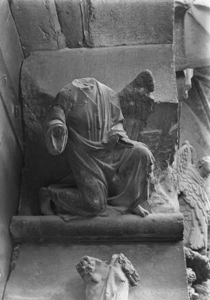 Südliches Westportal — Südlicher Türpfosten — Kniender Engel (i 8)