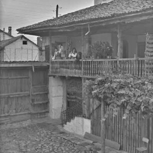 Veranda eines Wohnhauses in Bansko. Frauen in bulgarischer Tracht