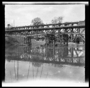 Unbekannte Gegend [Nordfrankreich?]: Holzkonstruktion einer provisorisch gestützten Eisenbahnbrücke über einen Fluss (Mittelstück)