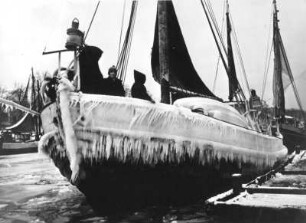 Küstenfischerei (Ostsee). Segel-Fischerboot, durch überkommendes Spritzwasser vereist, in einem Hafen