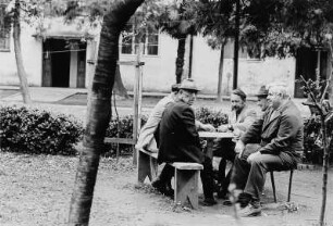 Männer an einem Tisch im Freien