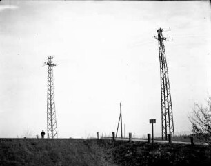 Deutschland. Erste 110 kV-Freileitung des Elektroarmaturenwerks Radebeul-Kötzschenbroda). Leitungsmasten an einer Landstraße