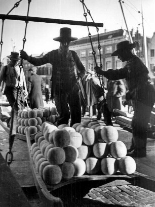 Niederlande. Die Käsestadt der Niederlande - Alkmaar. Die Käselast auf den Tragebrettern wird von den Käseträgern auf der Stadtwaage gewogen. Aufgenommen 1936. Seit 1622 findet jeden Freitag der Käsemarkt statt - das traditionelle Wiegen der Käselaiber gehört dazu.