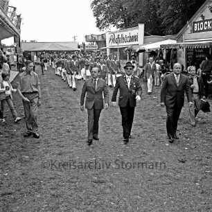 Volks- und Schützenfest: Fest- und Schützenplatz, Jersbeker Straße: Festumzug beim Einmarsch: Bürgermeister Erich Reinke, Vorsitzender des Schützenverein Bargteheide und Umgegend von 1908 e.V. Heiner Gülde, stellvertretender Bürgervorsteher Hans-Uwe Görtz: dahinter Spielmannszug: beiderseits Jahrmarktstände, Karussell, Zuschauer, 2. August 1981