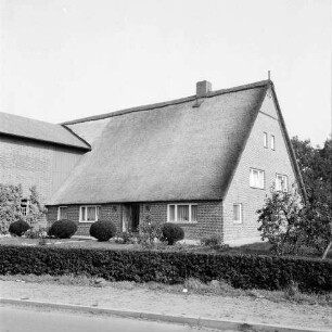 Dorfring: Bauernhaus mitt Reetdach: links Wirtschaftsteil: davor Garten mit Hecke