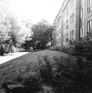 Cottbus. Puschkinpromenade. Parkweg mit Wall und Wohnblock nach Osten