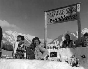 Winterbilder. "Schnee Bar Weinklause" (Ausschank im Freien) vor verschneiter Bergkulisse