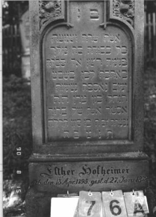 Grabstein 76 (Index: 100106505) Material: Sandstein Zustand: leicht, am Sockel stärker verwittert, Mittelaufsatz fehlt, Ornament nachgemalt Maße HxBxT: 134x48x15 cm Beschreibung: Rechteckstele mit Walmdach und Zinnenvorsatz, Mittelaufsatz fehlt, Schriftfeld eingetieft mit Schulterbogenabschluß, Sockel Symbolik: floral: Grabstein 76A