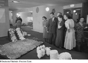 Besucher vor einem Ausstellungsstand einer Spinnerei