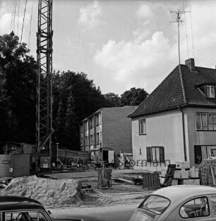 Sülzberg: in der Mitte Baustelle mit Ziegelstapel, Zementsäcken, Sandhaufen, Paletten, Baumaschinen, Bauwagen: rechts Wohnhäuser: links Baukran: dahinter Bäume