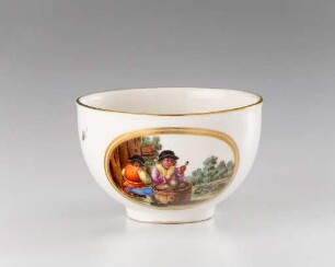 Teetasse mit zwei Landleuten an Tisch aus halbem Fass