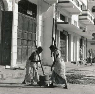 Rangun, Burma (Birma). Inderinnen stampfen Reis in einem Holzmörser