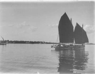 Segelboote : Zweimastiges Segelschiff im Hafen, im Hintergrund eine Stupa