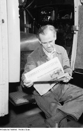 Porträt eines Arbeiters während des Lesens einer Zeitung