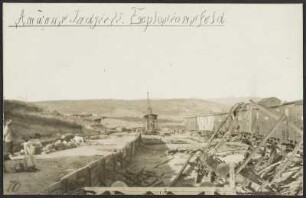 Güterhaltepunkt auf einem Berg im Amanus-Gebirge, Türkei, links im Bild wartende Männer und Ladung in Säcken, rechts kaputte Zugteile und Waggons, im Hintergrund ein Kran sowie der Blick auf die Gebirgskette