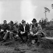 Munster: Truppenübungsplatz Munster-Nord: Gefechtsübung der Panzerbrigade 17: Feldbiwak: Stadtverordneter Dieter Achterberg und Bürgerworthalter Georg Koch auf Trage sitzend: links zwei Männer beim Essen: hinten Soldaten: 05.11.1975