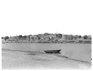 Varanasi (Benares), Indien. Stadtteilansicht mit Tempelanlagen. Blick vom Ganges zum Ufer mit Gläubigen