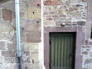 Langhaus (romanisch gegründet) im Südosten am Chor mit Sonnenuhr (romanisch) im Werkstein und Text -DHIDERID MISRE FECIT) sowie ein Textstein Jahr 1773 (Renovierung)