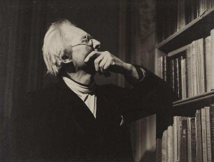 Edward Gordon Craig vor einem Bücherregal