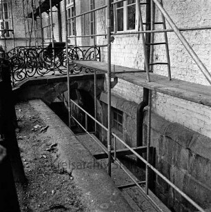 Restaurierung: Südost-Fassade mit Gerüst: Südportal, kleine Freitreppe mit Brückengewölbe, Geländer aus Schmiedeeisen: schmaler Lichtgraben als Rest von zugeschüttetem inneren Graben