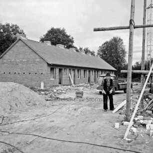 Wohnungsbau: "Im Weeden": Schlichtwohnungen des Amtes Bargteheide-Land für Obdachlose: Wohnblock im Rohbau: links Sandhaufen: rechts Gerüst: daneben Arbeiter: dahinter Baufahrzeug