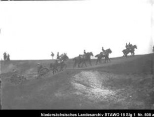 Geländeübung des Feld-Artillerie-Regiments Nr. 46 Enthält: Platte 15, Soldaten zu Pferd und auf einer mit Pferden bespannten Geschützlafette fahren eine Anhöhe hinauf